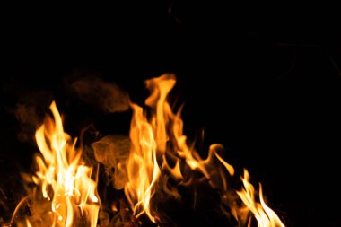 Siyah arka planda yangın. Soyut ateş dokusu. Gerçekçi alevler hareket çerçevesini yakar. Tasarım için doku. Ateşin dokusu. Yangın arka planı. Alevli kamp ateşi. Hassas odak.