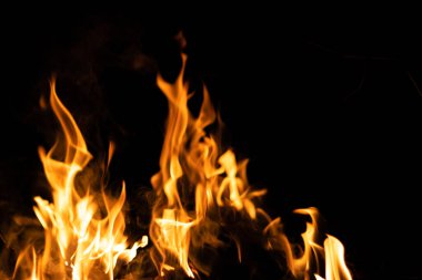 Siyah arka planda yangın. Soyut ateş dokusu. Gerçekçi alevler hareket çerçevesini yakar. Tasarım için doku. Ateşin dokusu. Yangın arka planı. Alevli kamp ateşi. Hassas odak.