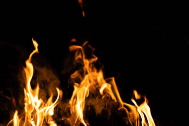 Siyah arka planda yangın. Soyut ateş dokusu. Gerçekçi alevler hareket çerçevesini yakar. Tasarım için doku. Ateşin dokusu. Yangın arka planı. Alevli kamp ateşi. Hassas odak.