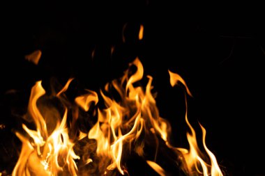 Siyah arka planda yangın. Soyut ateş dokusu. Gerçekçi alevler hareket çerçevesini yakar. Tasarım için doku. Ateşin dokusu. Yangın arka planı. Alevli kamp ateşi. Hassas odak.