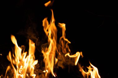 Siyah arka planda yangın. Soyut ateş dokusu. Gerçekçi alevler hareket çerçevesini yakar. Tasarım için doku. Ateşin dokusu. Yangın arka planı. Alevli kamp ateşi. Hassas odak.