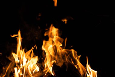 Siyah arka planda yangın. Soyut ateş dokusu. Gerçekçi alevler hareket çerçevesini yakar. Tasarım için doku. Ateşin dokusu. Yangın arka planı. Alevli kamp ateşi. Hassas odak.