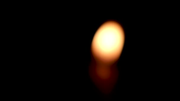 黒い背景に隔離されたキャンドルに燃える炎のぼやけたクローズアップ 闇の中のろうそくの炎 — ストック動画