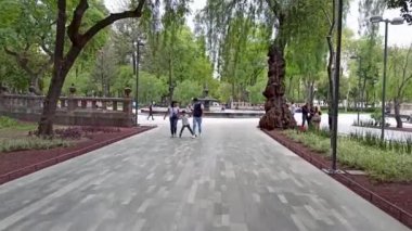 Mexico City, Meksika-Temmuz 2020: Paten kayarken oğullarının kollarını tutan çift, merkez alışveriş merkezi parkı boş zaman geçirmek isteyen ailelerin toplanma yeridir.