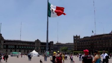 Mexico City, Meksika - Haziran 2021 Plaza de la Constitucin 'de Meksika bayrağı dalgalanırken Mexico City' deki en temsilci yerlerden biri olan Zocalo 'da yürüyen insanlar.