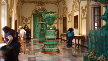 Mexico City, Meksika - Haziran 2021: Chapultepec kalesinde yer alan Sala de Malaquitas çeşmesinde İmparator Maximilian zamanından kalma nesneleri gözlemleyen insanlar