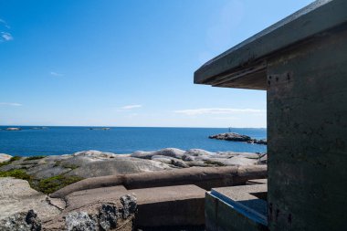 Norveç 'in güzel kıyıları kayalık oluşumları ve mavi sularıyla güzel bir yaz gününde İkinci Dünya Savaşı' ndan kalma eski sığınaklarla