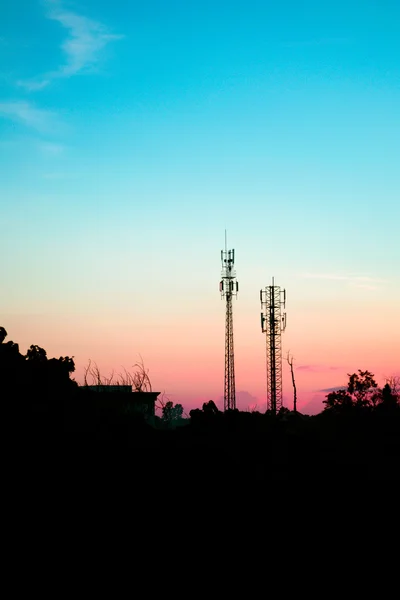 Sziluettjét antennával napnyugtakor ég — Stock Fotó