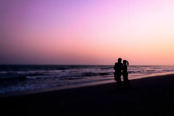 Silhouet van paren knuffelen op het strand — Stockfoto