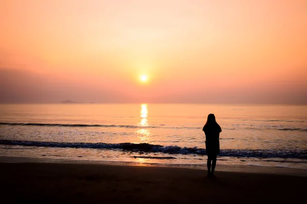 Silhouet van de vrouw alleen en golf op het strand — Stockfoto