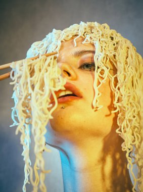 Kafasında kıvırcık erişte olan komik, aç bir kız..