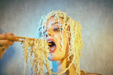 Kafasında kıvırcık erişte olan komik, aç bir kız..