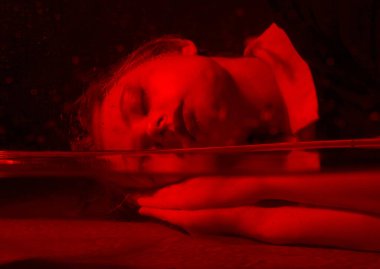 Korku odasında kırmızı ışığı olan genç bir kızın korkunç portresi..