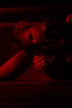 Korku odasında kırmızı ışığı olan genç bir kızın korkunç portresi..