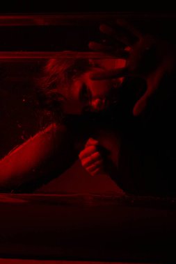 Korku odasında kırmızı ışığı olan genç bir kızın korkunç portresi..