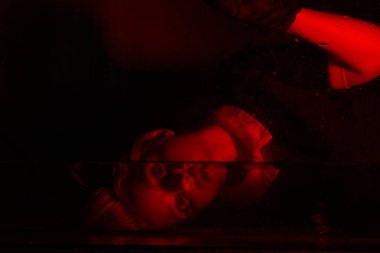 Korku odasında kırmızı ışığı olan genç bir kızın korkunç portresi..