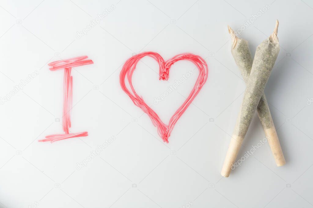 Love marijuana culture concept. Joint hemp and a drawn heart on a marker board.