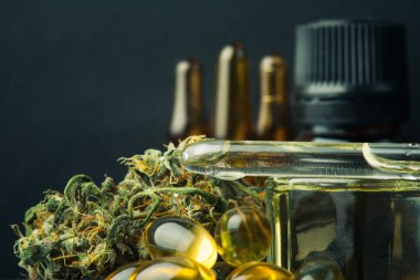 Esrar tomurcuğu ve petrol cbd 'si koyu, kapalı makro fotoğraf ürünü kenevir üzerinde.