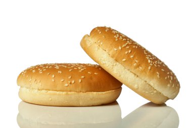 Beyaz arka planda izole edilmiş susam tohumlu yuvarlak hamburger ekmeği.