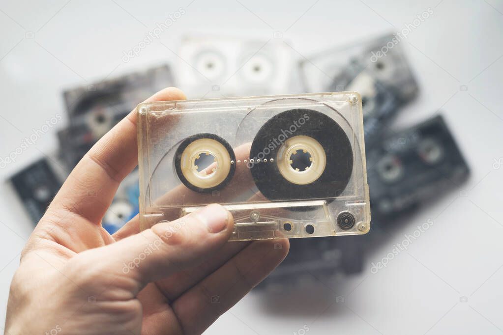 Hand holds the cassette. Retro tape cassette music. Old music.