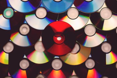 Bir sürü CD diski arkaplana yayılmış. Merkezi disk kırmızı..