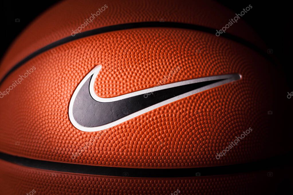 Nike brand, basketball ball Nike Baller. Orange rubber outdoor ball, ultra-durable cover, close-up on a black background.