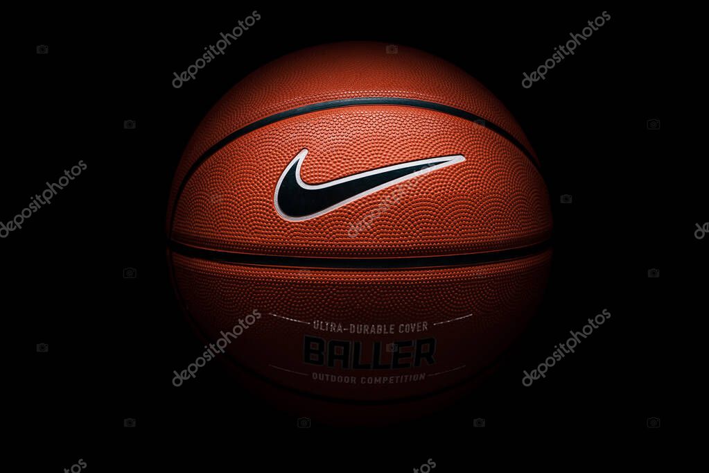Nike brand, basketball ball Nike Baller. Orange rubber outdoor ball, ultra-durable cover, close-up on a black background.