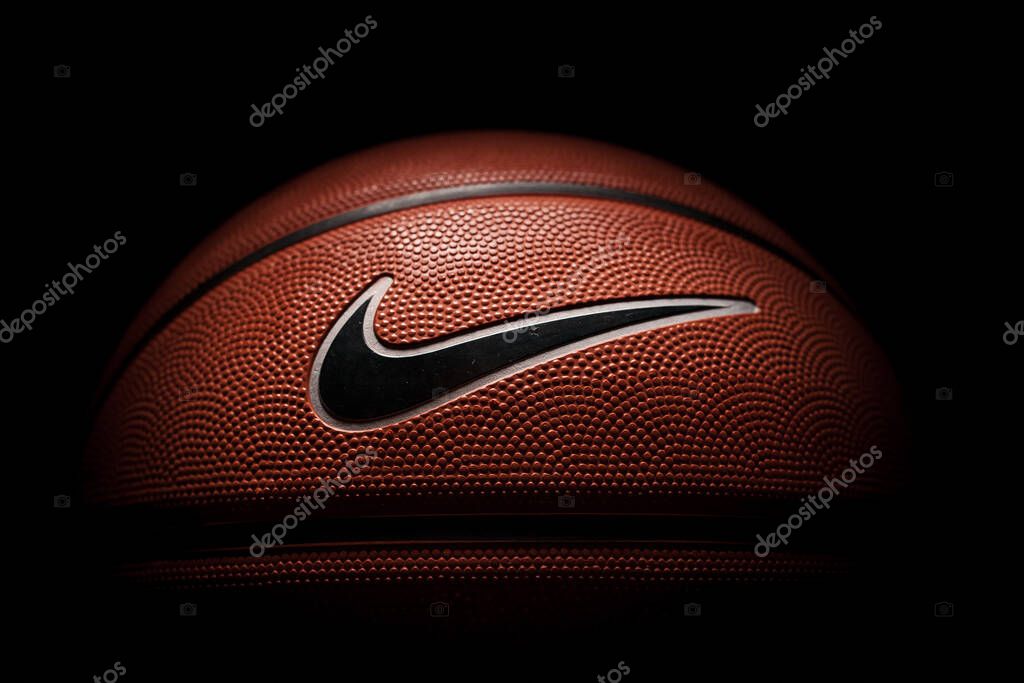 Nike brand, basketball ball Nike Baller. Orange rubber outdoor ball, ultra-durable cover, close-up on a black background.