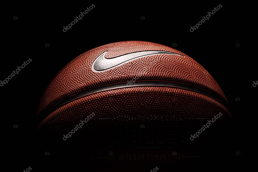 Nike brand, basketball ball Nike Baller. Orange rubber outdoor ball, ultra-durable cover, close-up on a black background.