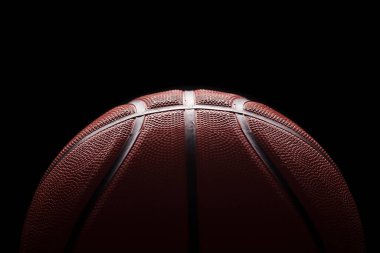 Siyah arka planda turuncu lastik top, başlık ve afiş için boş alan. Basketbol konsepti.