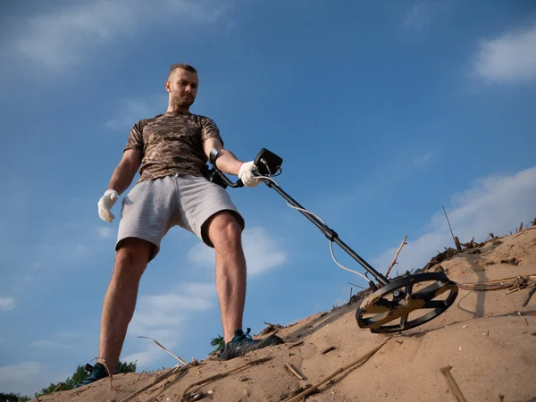 在阳光灿烂的夏日 带着金属探测器在沙滩上寻找宝藏的家伙 — 图库照片