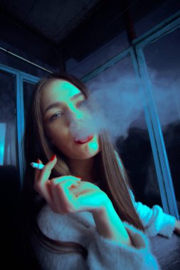 Genç güzel kız sigara içiyor. Yakından portre çekiyor..