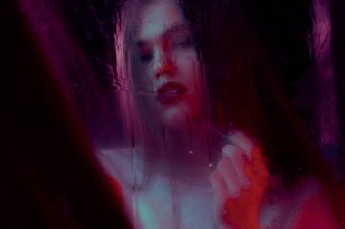 Islak ayna odaklanmıyor. Güzel genç kız aynaya bakarken makyaj yapıyor..