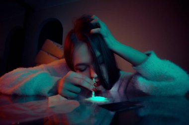 Beyaz kokain tozunu koklayan bir kızın portresi. Bağımlılık ve bağımlılık kavramı.