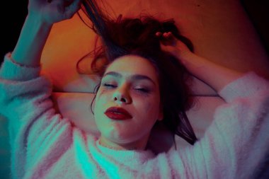 Genç kız uyuşturucu etkisi altında odada yatan bir uyuşturucu bağımlısı. Uyuşturucu kullanımı, aşırı doz kavramı. Gençlerin yasadışı madde kullanmasını savunmak.