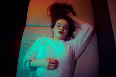 Güzel genç kız odasında kanepede yatmaktan sıkılmış..