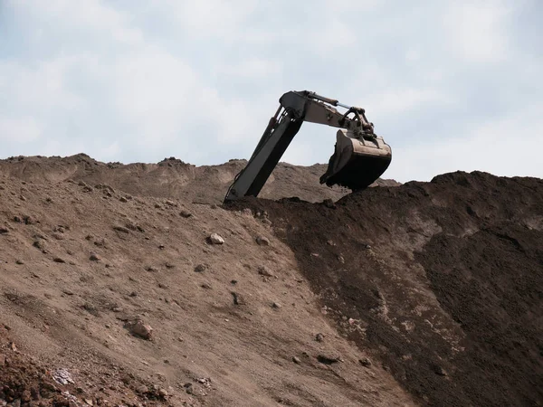 Excavator works on a dump in open pit mining. Heavy construction equipment. Quarry mining.