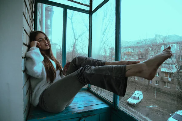 漂亮的年轻性感姑娘在阳台上摆姿势 现代风格的女孩的艺术摄影肖像 照片上有坐姿和附加的噪音 — 图库照片