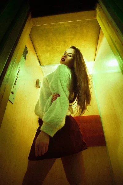 具有增加噪音 垂直方向的艺术照片 一个漂亮的姑娘站在电梯里 穿着时髦的衣服 — 图库照片