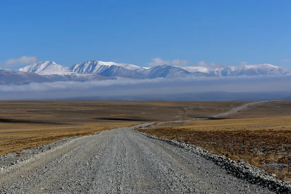 Road steppe mountain snow clouds — Stock Photo, Image