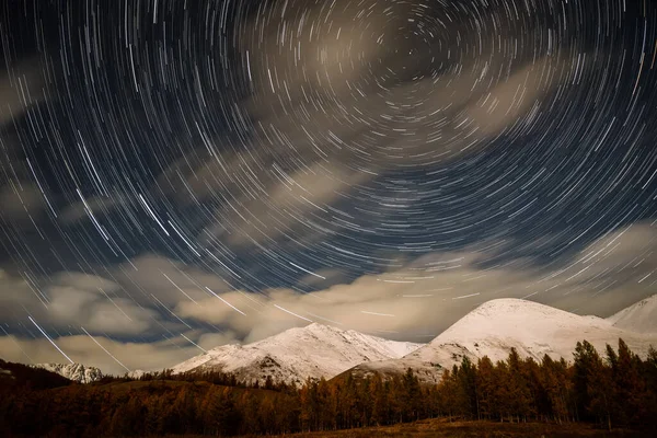 秋の月明かりの下で雪の山の上の空のトラックの形で雲や星とカラフルな夜の風景 — ストック写真