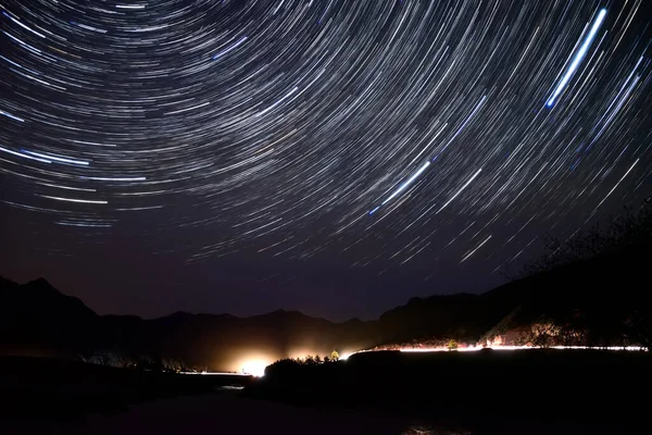 川や車のヘッドライトの光の中で橋の上に空のトラックの形で星と夜の風景 — ストック写真
