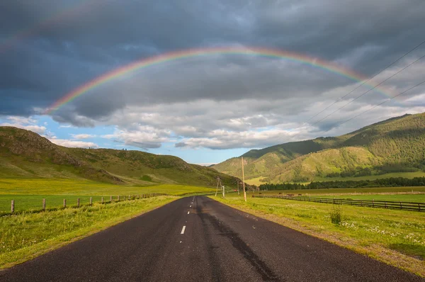 Arc-en-ciel montagne route champ — Photo