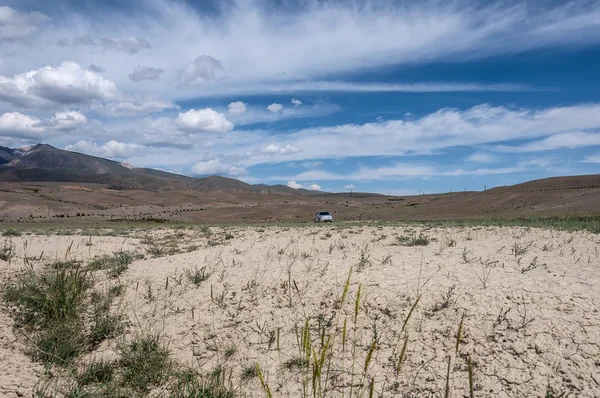 Estepe deserto montanhas céu carro — Fotografia de Stock