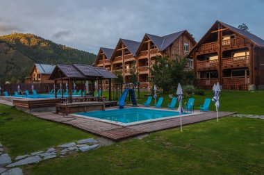 Alacakaranlıkta dağlarda modern ahşap otel
