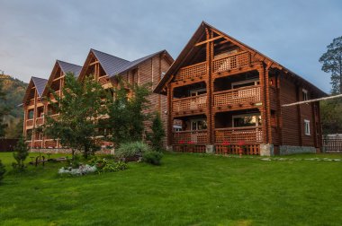 Alacakaranlıkta dağlarda modern ahşap otel