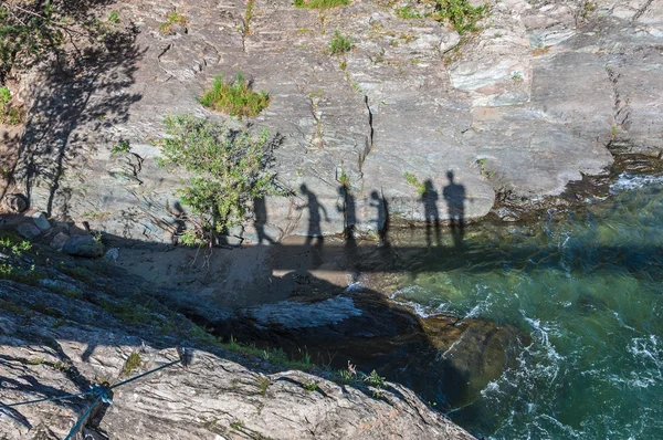 Sombras de pessoas andando na ponte suspensa — Fotografia de Stock