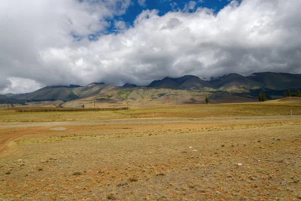 Dağlar vadi toprak yol bulutlar — Stok fotoğraf