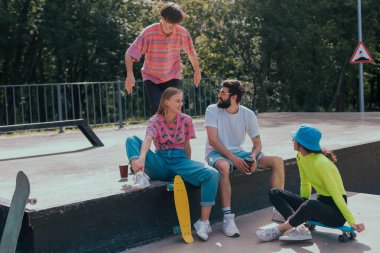 Güneşli bir günde, bir grup arkadaş çok çekici, çok ırklı modern bir kaykay parkında eğleniyor yerde oturuyor ve kaykay yapmaya başlamadan önce sosyalleşiyorlar.