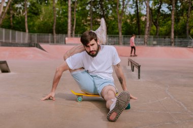 Dışarıda kaykay kullanan genç bir adam.